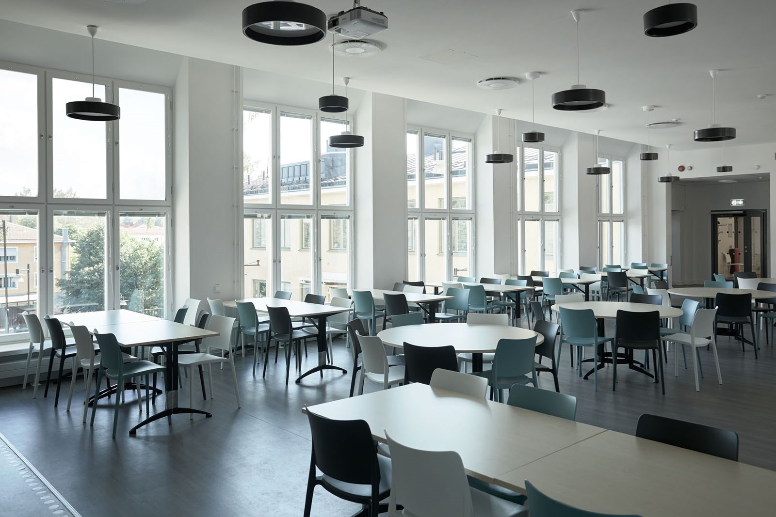 Bild på matsal i Enskedefältets skola med flera bord och stolar.